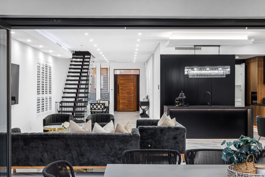 Image shows a Benelong Projects residential home with Open Plan Living, dining, and kitchen area. Complete with marble floors, high-end interior design and decor