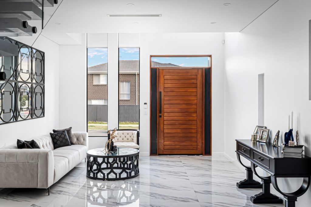 Image shows a welcoming entrance / foyer area with exquisite marble floors and seating. Benelong projects residential building home