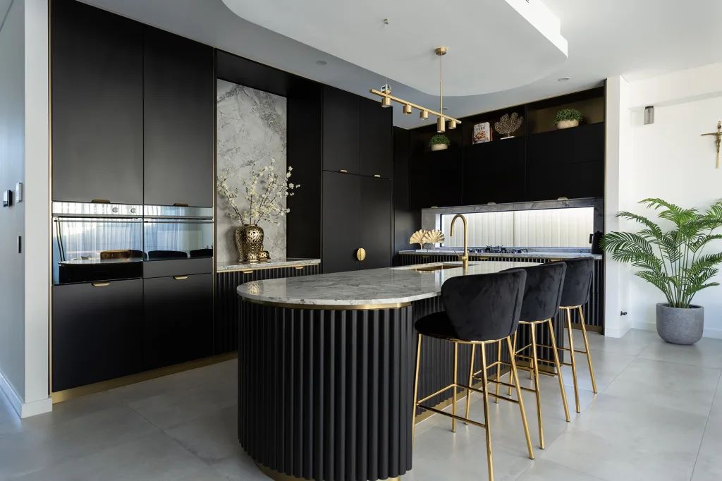 Image shows a kitchen with granite bench tops, stone tiled floors and breakfast bar