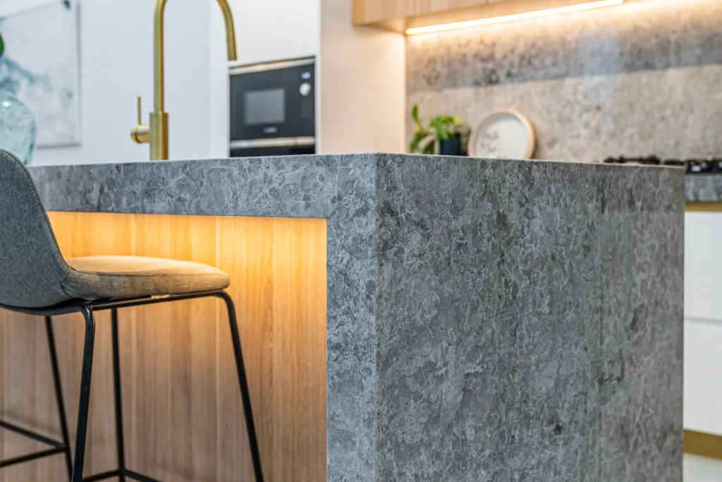 Image shows a portion of a kitchen built from grey granite