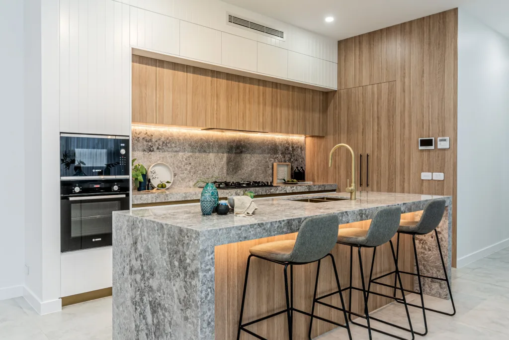 Image shows a kitchen island bench with granite bench tops in a Sydney Home