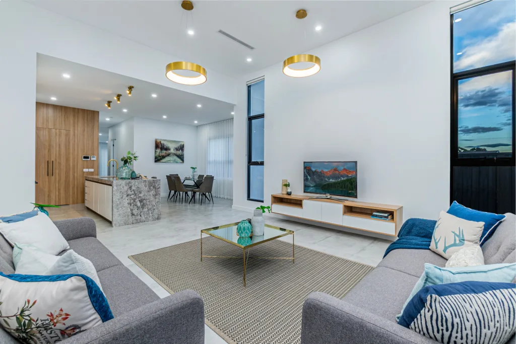 Image shows a living area with white stone tiles, white walls and comfortable sofas